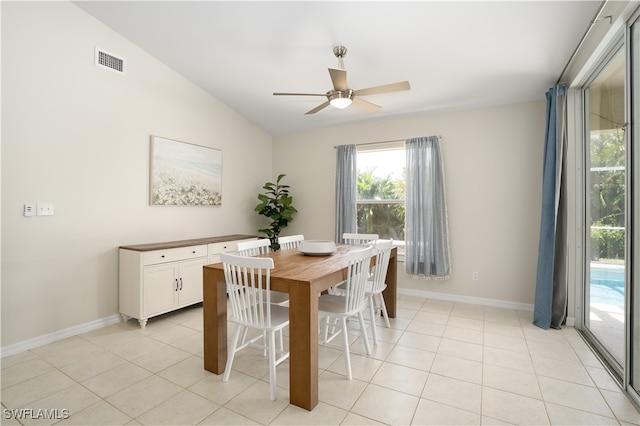 dining room with ceiling fan, vaulted ceiling, and light tile patterned floors