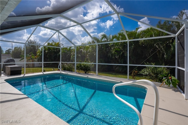 view of pool with a patio area and glass enclosure