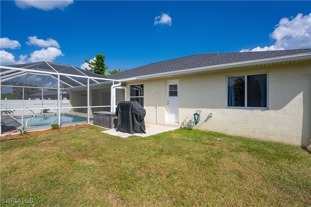 rear view of house with a patio area, a lanai, and a lawn