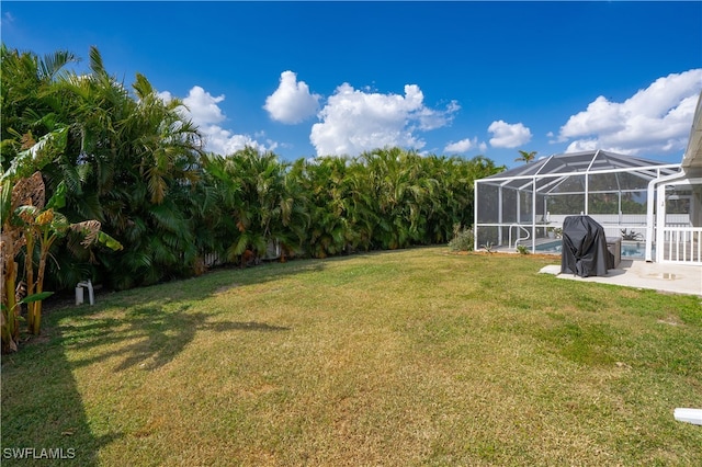 view of yard with a patio area and glass enclosure