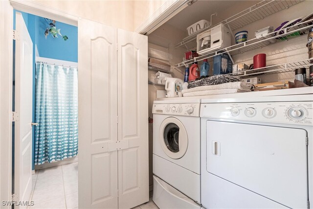 laundry area with washing machine and dryer and light tile patterned flooring