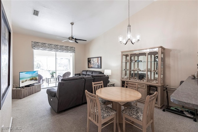 dining room featuring carpet flooring, vaulted ceiling, and ceiling fan with notable chandelier