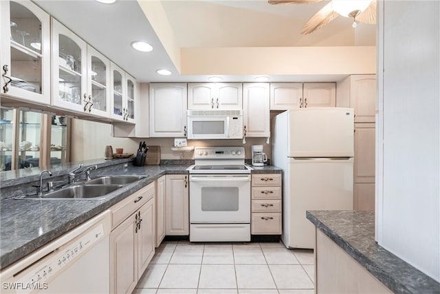 kitchen featuring white appliances, light tile patterned floors, and sink