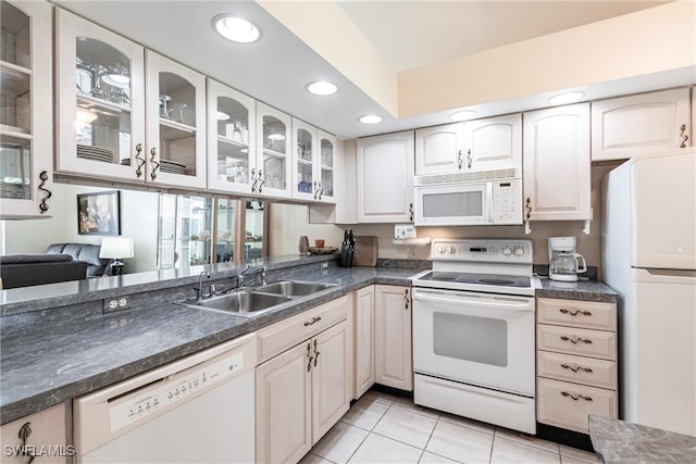 kitchen featuring white appliances, light tile patterned floors, sink, and white cabinets