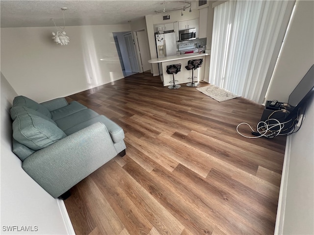 living room with visible vents, a textured ceiling, and wood finished floors