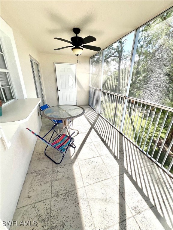 unfurnished sunroom featuring a ceiling fan