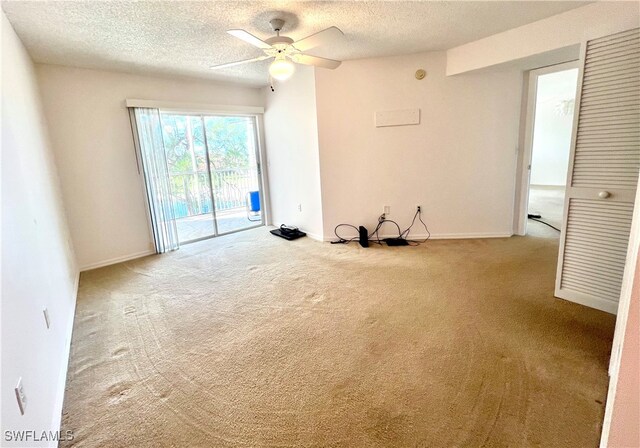 spare room featuring ceiling fan, carpet, and a textured ceiling