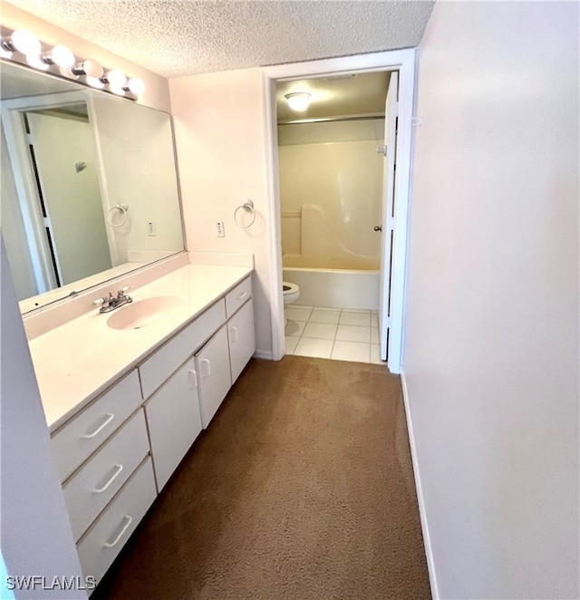 bathroom with toilet, a textured ceiling, tile patterned flooring, baseboards, and vanity