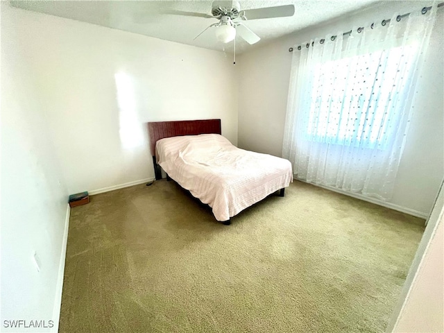 carpeted bedroom featuring a ceiling fan and baseboards