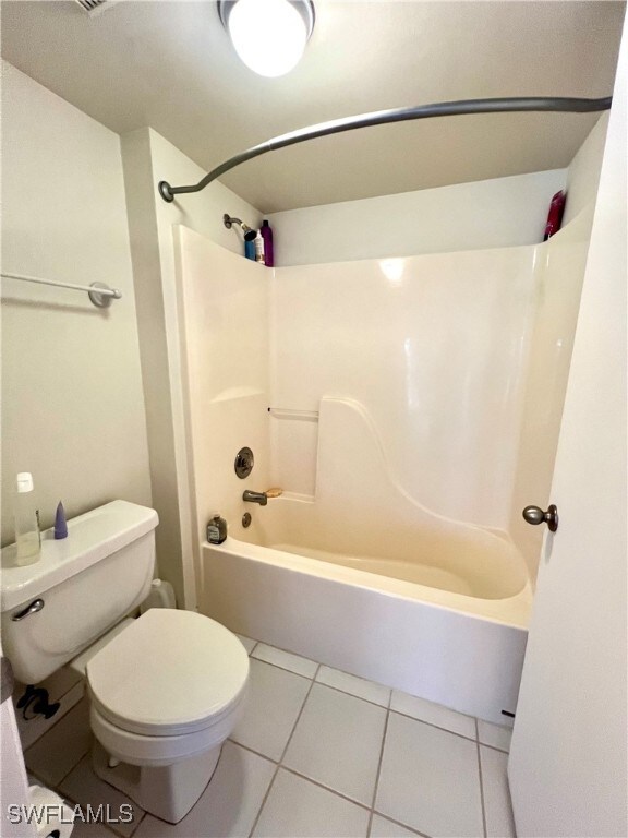 bathroom featuring toilet, bathtub / shower combination, and tile patterned floors