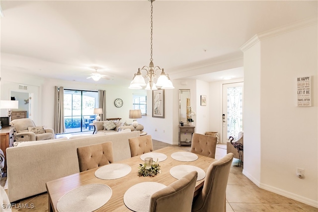 tiled dining space featuring crown molding and ceiling fan with notable chandelier