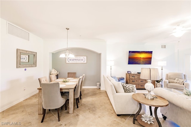 dining space with crown molding and ceiling fan with notable chandelier