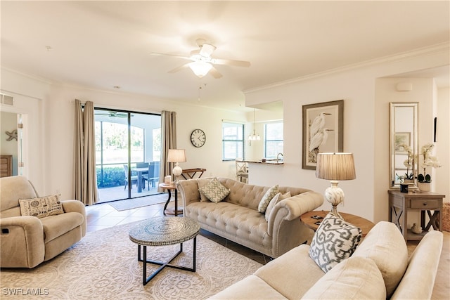 tiled living room with ceiling fan and ornamental molding