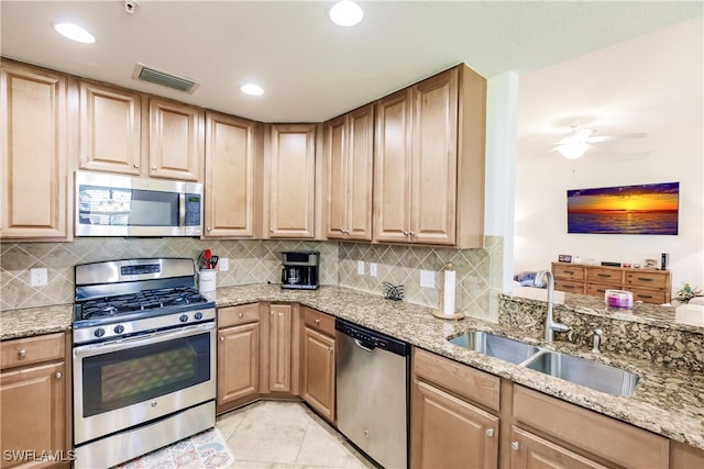 kitchen featuring light tile patterned floors, backsplash, ceiling fan, sink, and stainless steel appliances