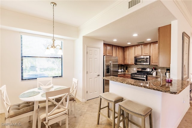 kitchen with decorative backsplash, hanging light fixtures, stainless steel appliances, dark stone countertops, and an inviting chandelier