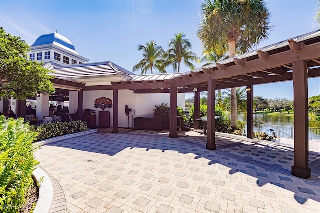 view of patio / terrace featuring a water view and a pergola