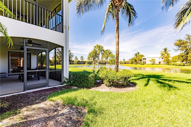 view of yard with a water view and ceiling fan