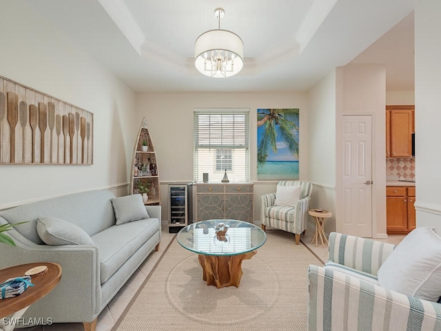 living room featuring a tray ceiling, a chandelier, and beverage cooler