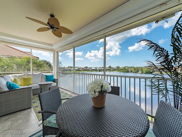 sunroom / solarium with a water view and ceiling fan