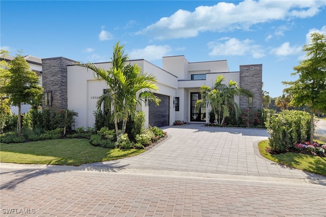 contemporary house featuring a front lawn and a garage