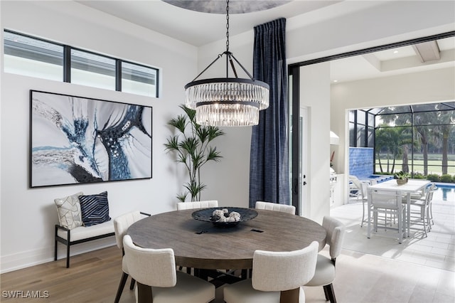 dining area with light wood-type flooring, a chandelier, and plenty of natural light