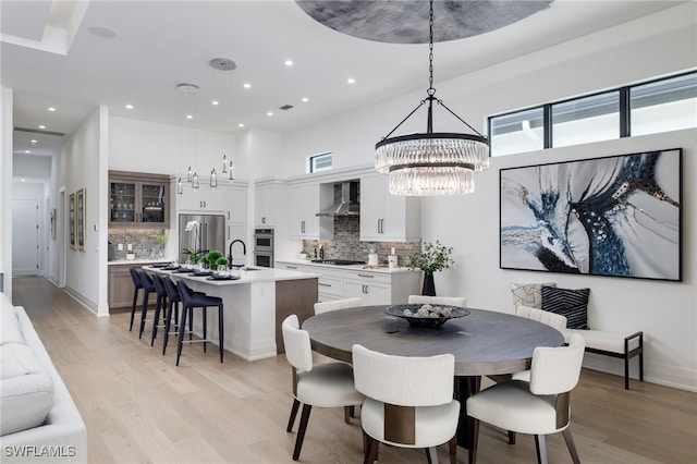 dining room with light hardwood / wood-style floors and a notable chandelier