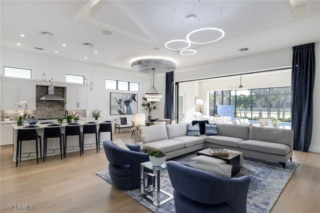 living room featuring recessed lighting, an inviting chandelier, a wealth of natural light, and light wood-style floors