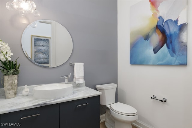 half bathroom featuring vanity and toilet