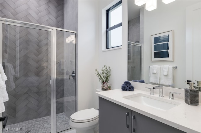 bathroom featuring vanity, toilet, and an enclosed shower