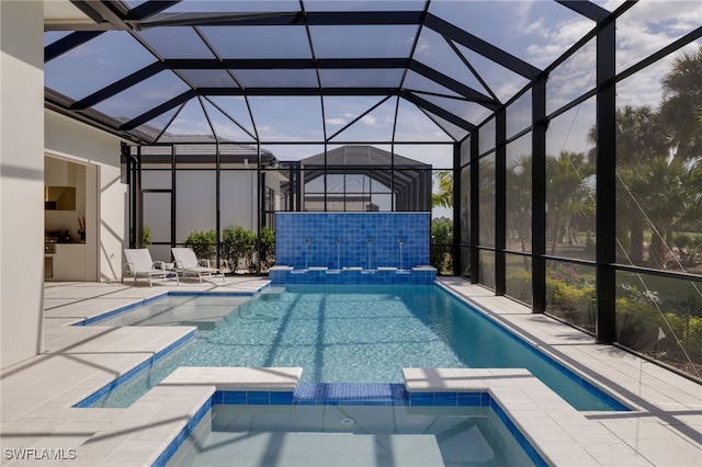 view of pool with a patio, a lanai, and an in ground hot tub