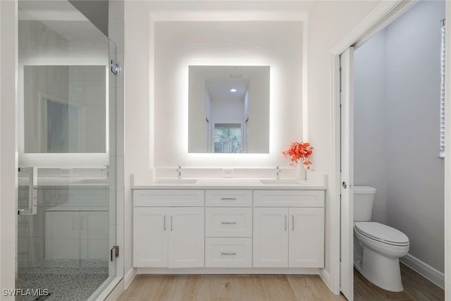 bathroom with vanity, hardwood / wood-style flooring, toilet, and walk in shower