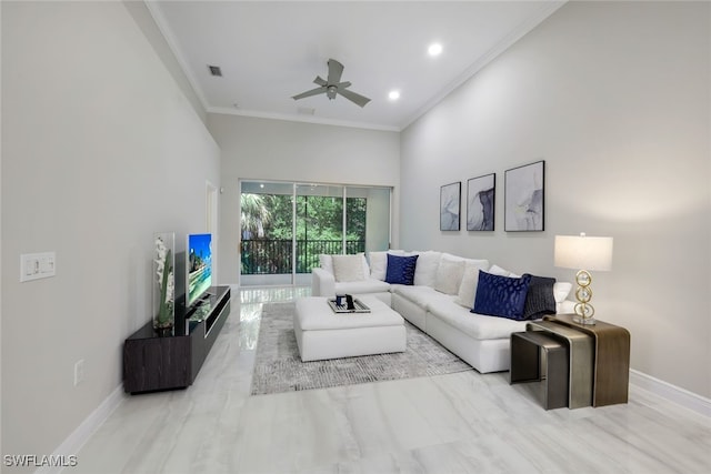 living room with a towering ceiling, ceiling fan, ornamental molding, and light hardwood / wood-style flooring