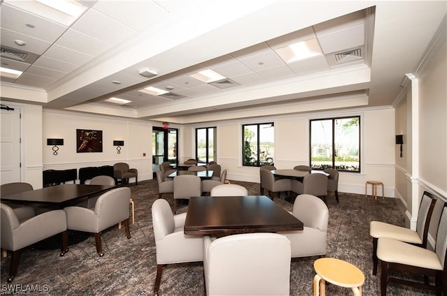 dining room with crown molding, a tray ceiling, a paneled ceiling, and dark colored carpet