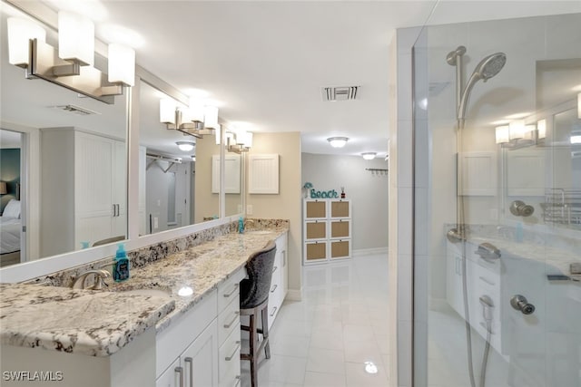 bathroom with tile patterned floors, vanity, and a shower with door