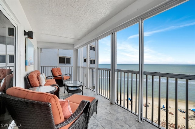 sunroom / solarium with a view of the beach and a water view