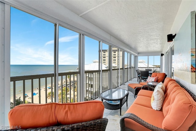 sunroom / solarium with a water view and a view of the beach