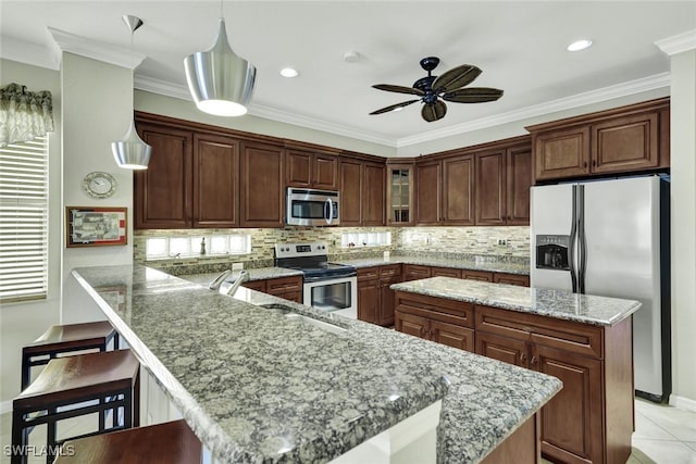 kitchen with a kitchen bar, light stone counters, stainless steel appliances, decorative light fixtures, and a center island