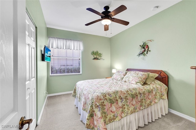 bedroom featuring ceiling fan, a closet, and light colored carpet