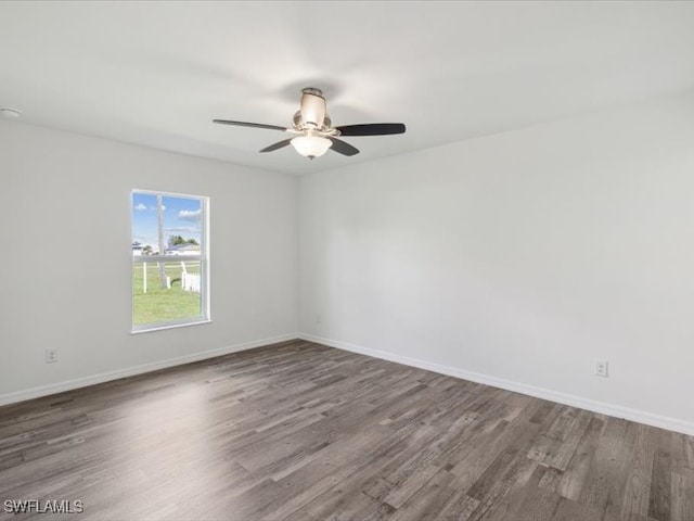 spare room with dark hardwood / wood-style floors and ceiling fan