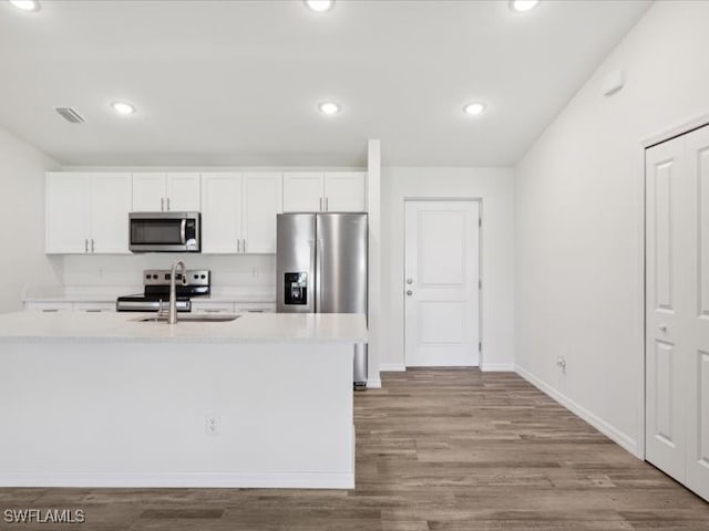 kitchen with sink, white cabinets, stainless steel appliances, and light wood-type flooring