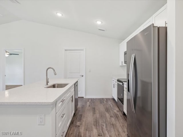 kitchen featuring appliances with stainless steel finishes, white cabinetry, sink, and vaulted ceiling