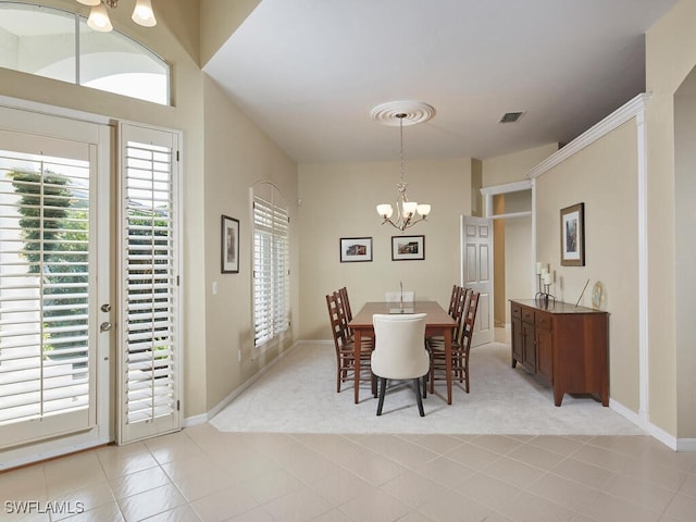 dining room featuring a chandelier, light tile patterned floors, and lofted ceiling