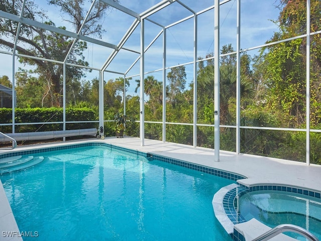 view of swimming pool featuring glass enclosure, an in ground hot tub, and a patio