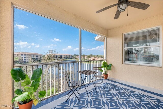 balcony with a water view and ceiling fan