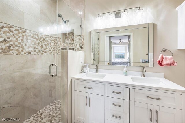 bathroom with vanity, a shower with shower door, and ceiling fan