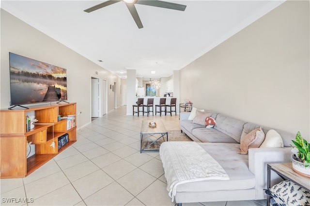 tiled living room with ceiling fan and crown molding