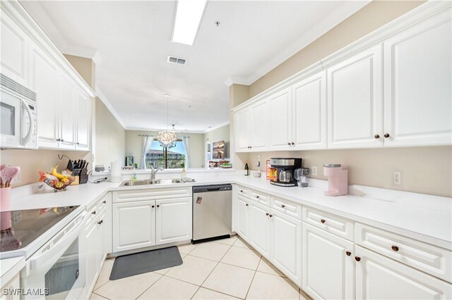 kitchen with crown molding, sink, decorative light fixtures, white cabinets, and white appliances