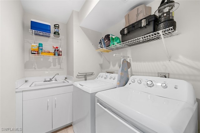 laundry area featuring washer and clothes dryer, sink, and light hardwood / wood-style floors