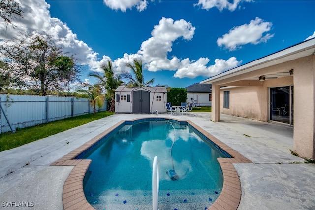 view of pool with a patio, a shed, and ceiling fan