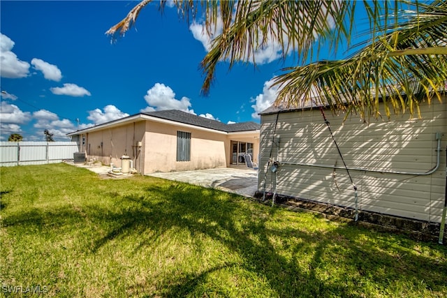 back of property with a patio area and a lawn